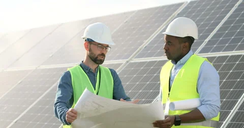 Two engineers in special uniform discuss holding plan of solar panels. African Video stock 139507616