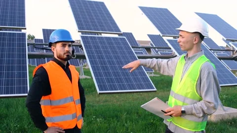Two engineers in special uniform discuss the installation of sunny batteries Stock Footage 140002261