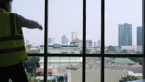 Two engineers stand front large window of the office Видео 129584743