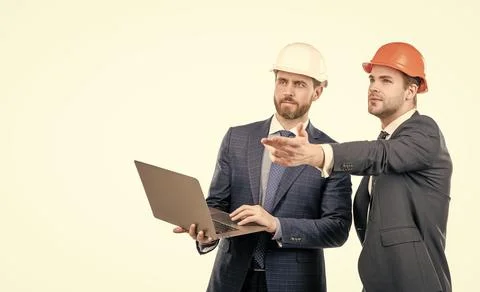Two engineers in suit and protective helmet use laptop isolated on white copy Stock Photos