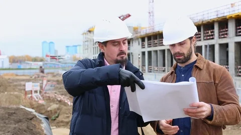 Two engineers talk about the project for the construction building. They look at Video stock 97121168