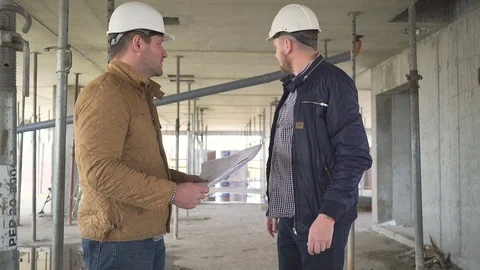 Two engineers talking about details of building project at construction. Stock Footage 72358654