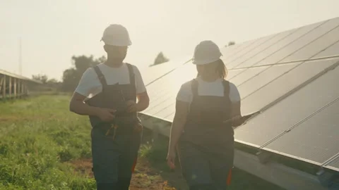 Two engineers walk around checking the functionality of a solar farm. Stock Footage 255981468