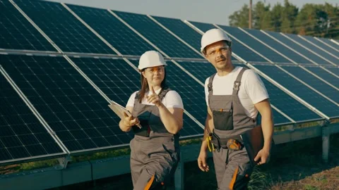 Two engineers walk around checking the functionality of a solar farm. Stock Footage 256748455