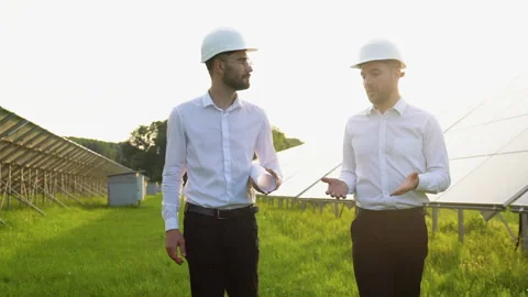 Two engineers walking at solar farm and discussing efficient plan of Stock Footage 245577314
