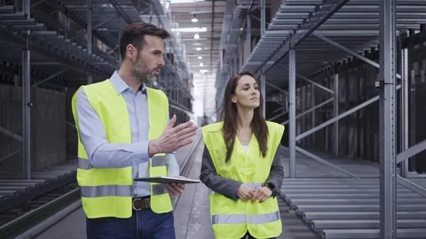 Two engineers walking through factory discussing work related topics Stock Footage 108453396