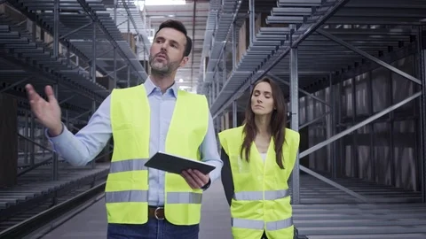 Two engineers walking through factory warehouse and talking Stock Footage 108458666