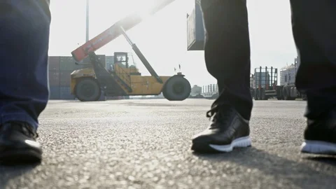Two engineers wearing hardhats talking together while walking on a large Stock Footage 101232839