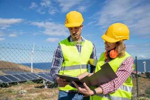 Two engineers at work analyze data in the solar farm, female and male coworke Foto stock