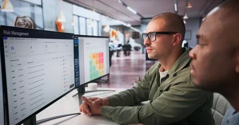 Two Enterprise Risk Managers Use Computer Tools To Analyze Financial Data Col Stock Photos