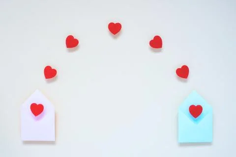 From two envelopes fly red hearts. On a light background Photos