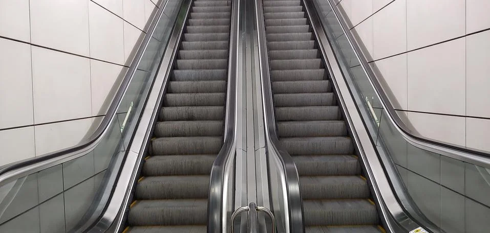 Two escalators that move up and down Stock Photos