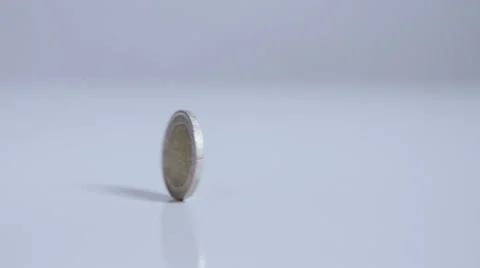 Two-Euro coin rolling in one place, on white surface slow motion Stock Footage 58761258
