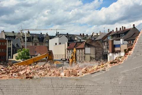 Two excavators are sorting out the rubble of buildings destroyed for dismantling Stock Photos