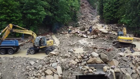 Two excavators eliminate the gust of a mountain river on the highway. Shift of Stock Footage 197486078