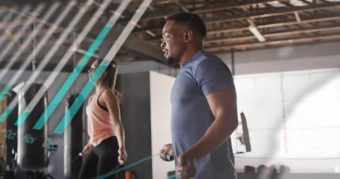 Two exercisers jumping rope on first swing, teal charts sweeping over them for Stock Footage 323373013