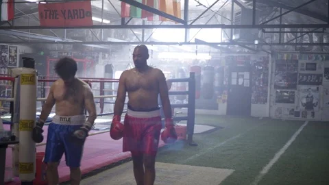 Two Exhausted Athletic Men Hug in Boxing Gym Stock Footage 125284982