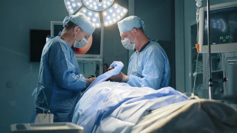 Two experienced surgeons perform operation in fully-equipped operating room Stock Footage 254517409