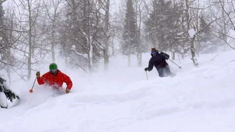 Two expert males ski deep powder snow together in Park City, Deer Valley, Utah. Stock Footage 99257962