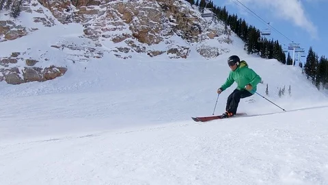 Two expert skiers turn in slow motion, wide-angle camera on a Utah ski slope. Stock Footage 99470778