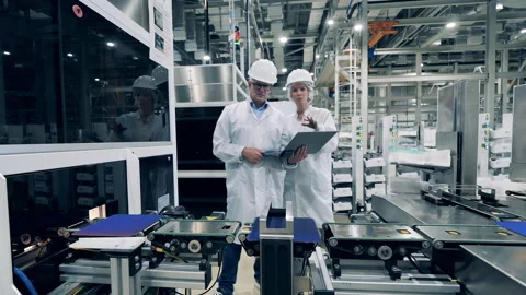 Two experts are observing robotized conveyor with solar cells Stock Footage 168139844