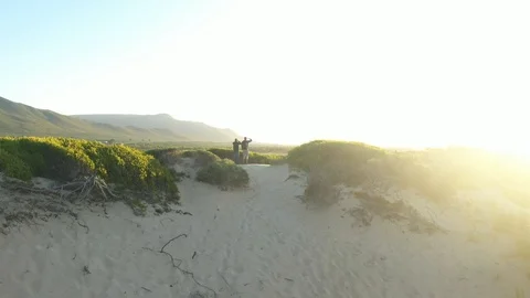 Two explorers hiking a mountain sanddune sunset sunrise 2 Stock Footage 127303480