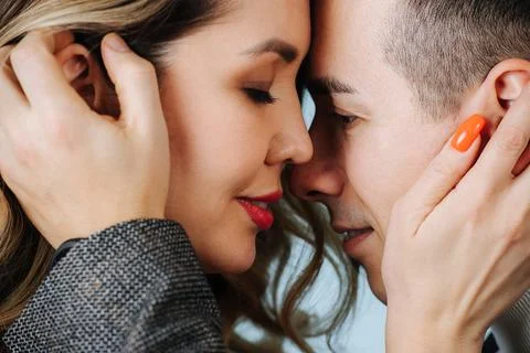 Two faces of lovers, touching each other with their hands and noses Stock Photos