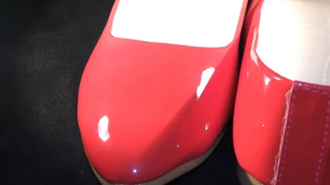 Two facing red shoes circling on the wheel and on black surface Stock Footage 111274014