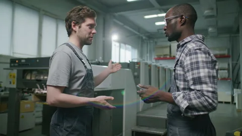 Two Factory Technicians Shaking Hands and Discussing Printing Press Operation Stock Footage 335483456