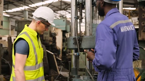 Two factory worker talking about maintenance and check the industrial machine. Stock Footage 141235670