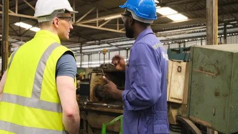 Two factory workers discussion with maintenance plan of industrial machine. Stock Footage 141235693