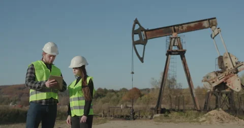Two factory workers discussion with tablet pc. Industrial background. Male and Stock Footage 195249922