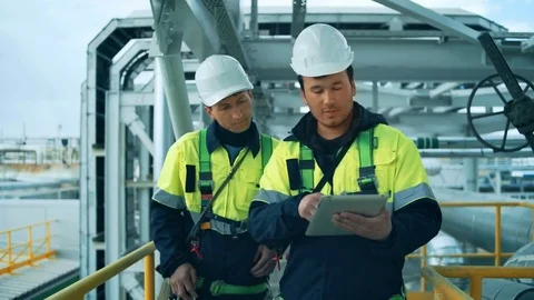 Two factory workers walking and discussion with tablet pc. Industrial background Stock Footage 76682527