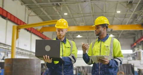 Two factory workers walking with discussion holding tablet pc. Industrial heavy Stock Footage 120918240