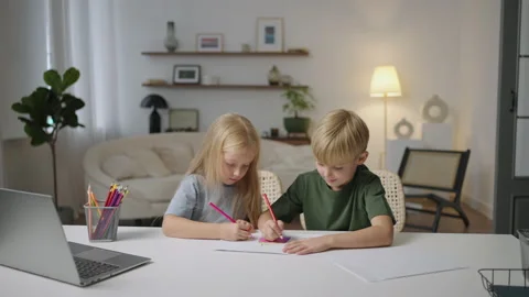Two fair-haired children together, a boy and a girl, look at the laptop screen Stock Footage 219544581