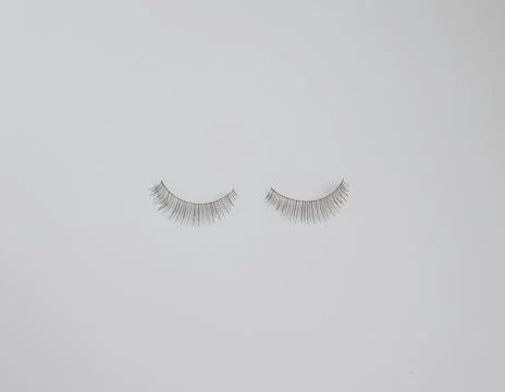 Two false eyelashes against plain white background with copy space Stock Photos
