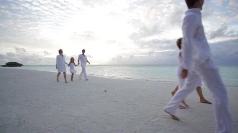 Two families walking on beach at sunset Stock Footage 1055879