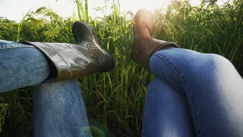 Two farmers are resting lying in the field, close-up of legs Stock Footage 135633232
