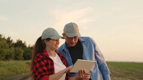 Two farmers working tablets, field group conversations, group transactional Stock Footage 245864686