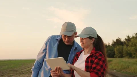 Two farmers working tablets, field group conversations, group transactional Stock Footage 245952472