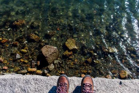 Two feeet standing on waters edge Stock Photos