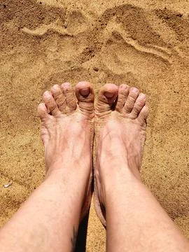 Two feet in the sand Stock Photos