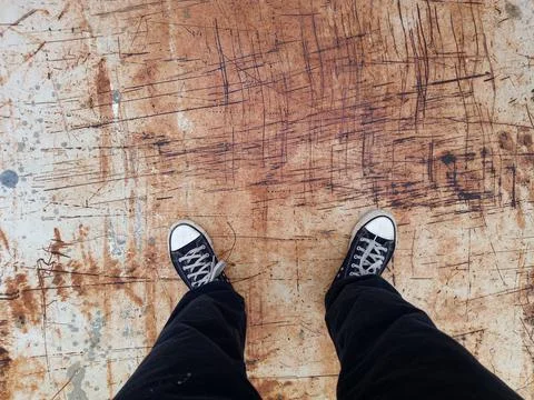 Two feet stand on a rusty sheet of metal Foto stock