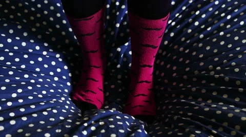 Two feets with cool socks that jumping and having fun on bed Stock-Footage 56706935