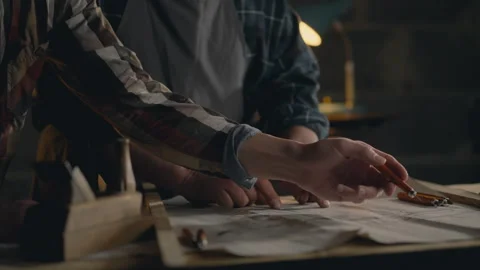 Two fellow employees are studying drawings of wooden parts for manufacturing Stock Footage 261558653