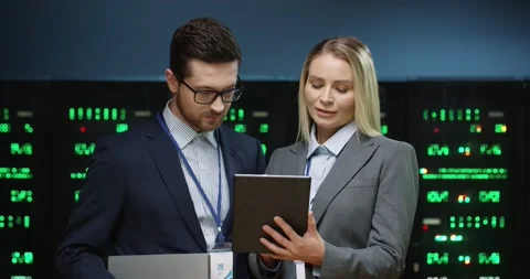 Two fellow programmers stand in server room and discuss work tasks looking at Stock Footage 152056257