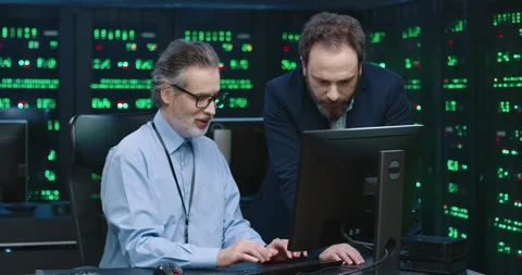 Two fellow programmers work together in office with servers and look at computer Vídeos de archivo 145298295