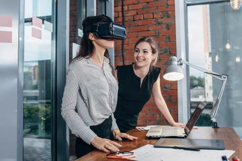 Two female application developers testing a new app designed for VR headset Stock Photos