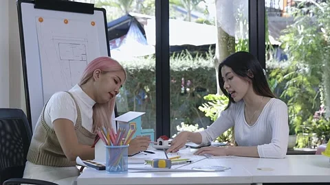 Two female architects working together on building models and blueprints. Stock Footage 317808037