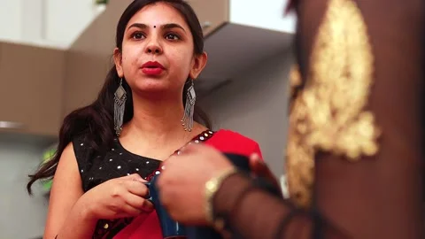 Two female best friends drinking tea or masala tea together at home in saree Stock Footage 146327892